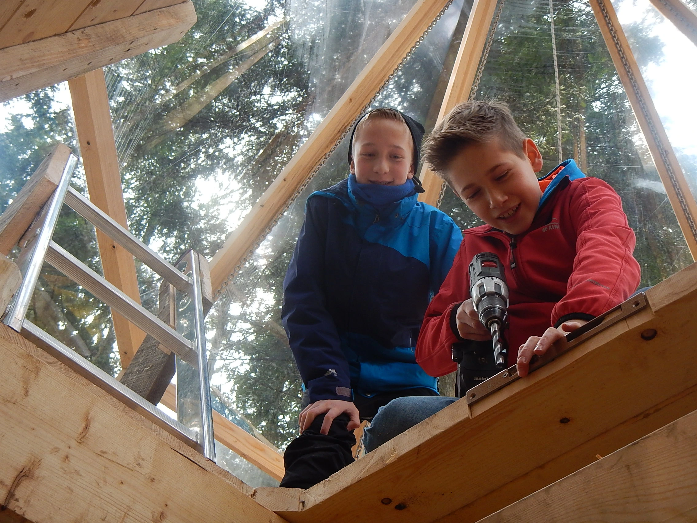 Kinder und Jugendliche bauen gemeinsam ein Baumhaus welches später für die Baumhausübernachtung zur Verfügung steht