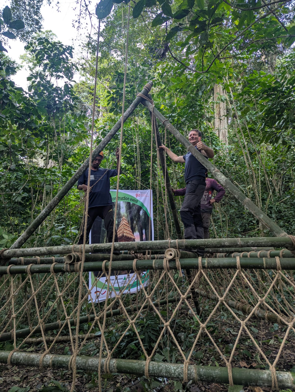 internationalen Online-Workshop ‚Designing Treehouses and Hiking Huts‘ am 27. Oktober 2025. Visualisiert sind ein stilisiertes Baumhaus, tropischer Regenwald und die Logos der Veranstalter: Bund für Baumhaustechniker e. V., GIZ und indonesisches Forstministerium.