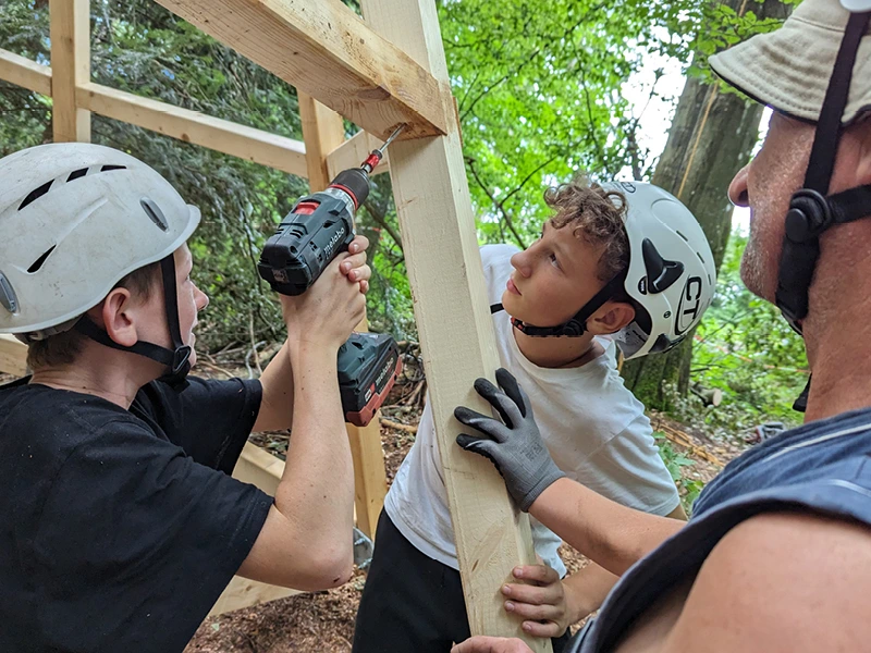 Kinder Bauen mit Schutz am Baumhaus.